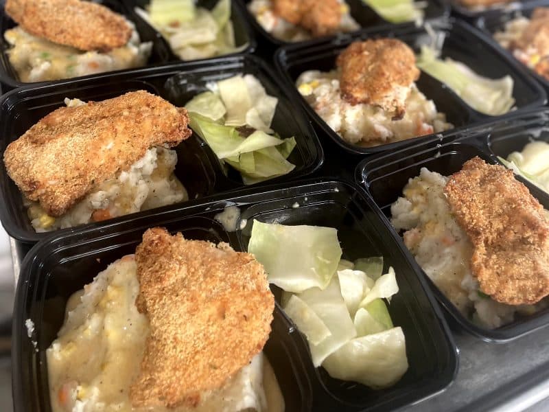 Prepared meal trays with breaded chicken, mashed potatoes, and cabbage