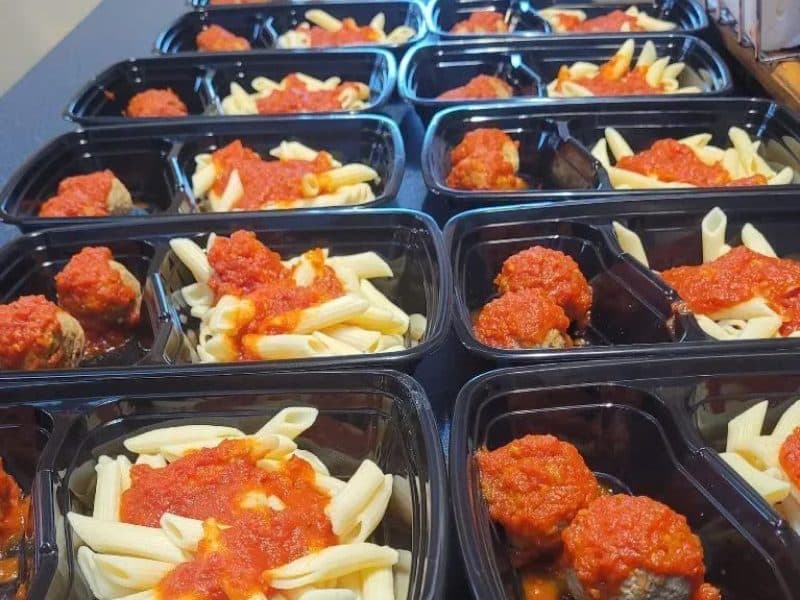 Prepared Italian-style meal in a delivery tray
