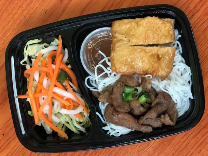 Prepared Vietnamese-style meal with noodles, vegetables, and protein
